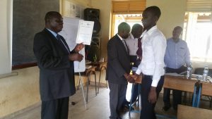 Mr. Kyaka from MOES awarding certificates to participants